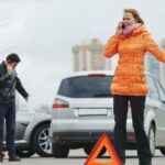 a woman calling the police after a car accident