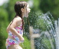 girl playing in sprinkler x